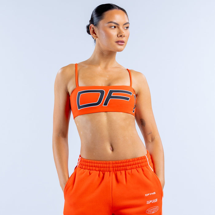 Orange sports bra with bold OF logo and contrast striped trim on wide straps