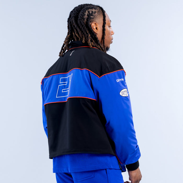Kids track jacket back view, black and blue with red piping and logo panels