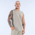 Beige sleeveless crew-neck tank top with straight hem, worn by a model