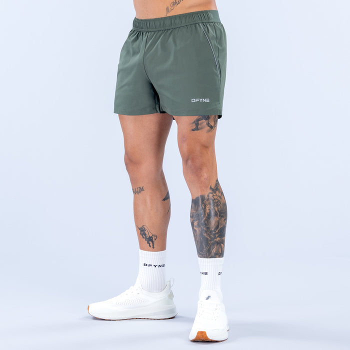 Dark green training shorts with elastic waistband and small back logo patch