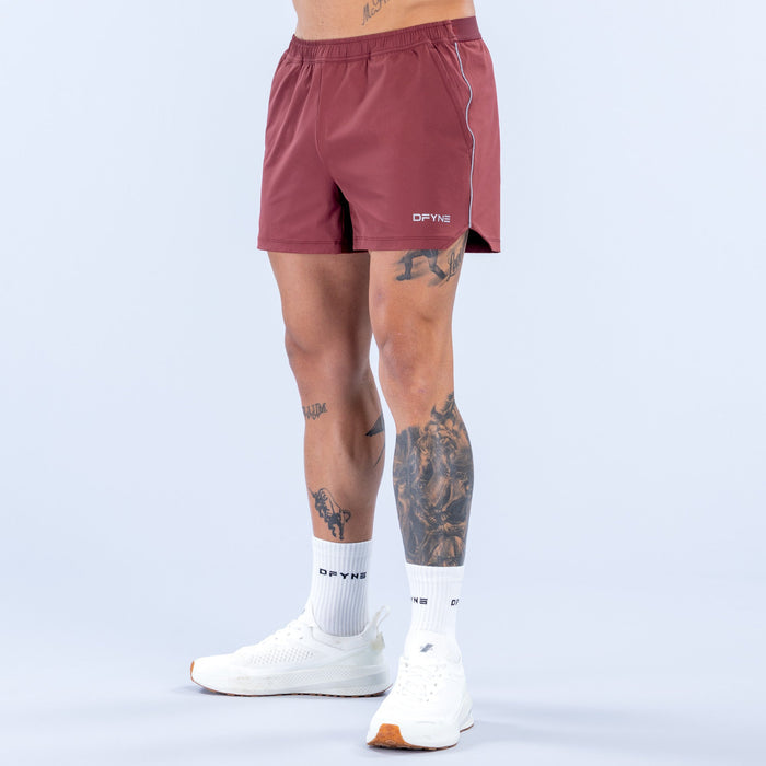 Burgundy 4-inch training shorts with elastic waistband and side seam piping