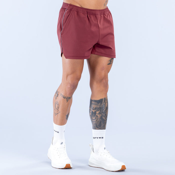 Burgundy 4-inch training shorts with elastic waistband and side stripe trim