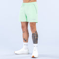 Light green training shorts with elastic waistband and 6-inch inseam, side logo