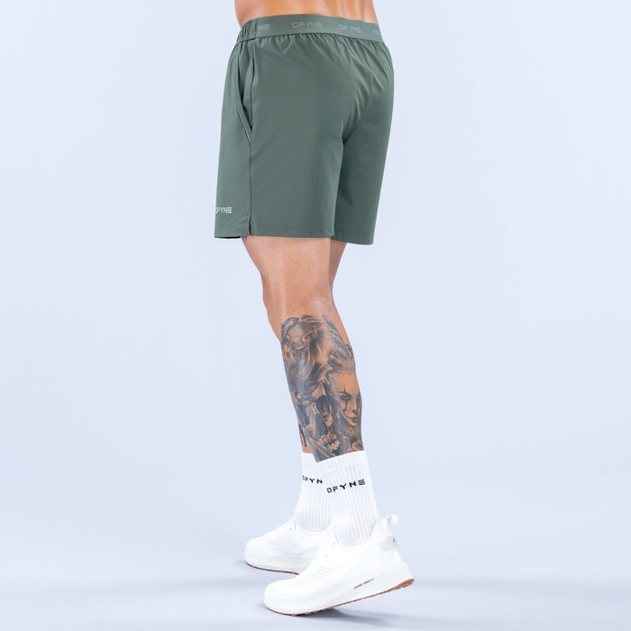 Dark green 6-inch training shorts, side view with elastic waistband and clean hem.