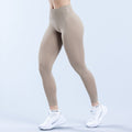 Beige high-rise leggings with subtle side seam detail and logo at waistband