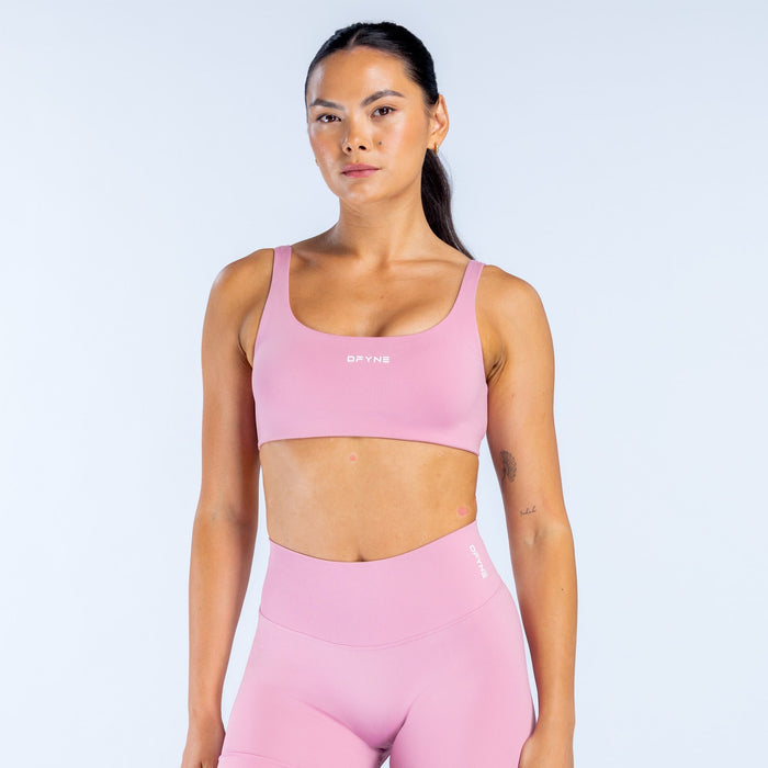 Pink scoop-back sports bra with racerback straps and a smooth, stretchy fit
