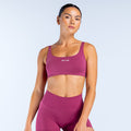 Magenta scoop back sports bra with wide scoop neckline and logo at center front