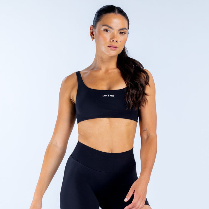 Black scoop-back sports bra with scoop neckline and DPYNE logo front.