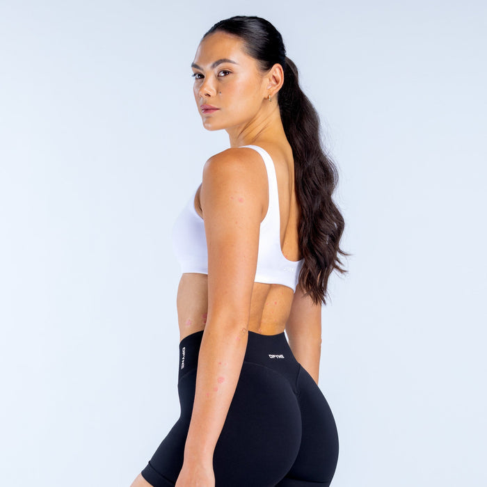 White scoop-back sports bra with visible back straps and wide neckline
