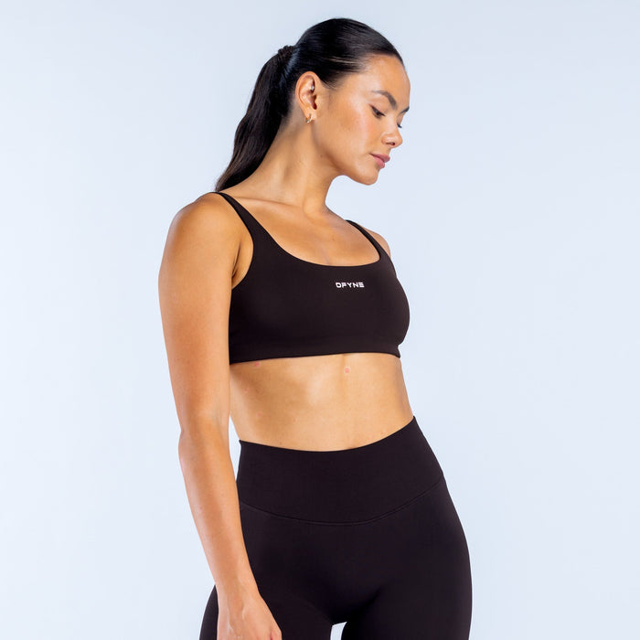 Black scoop back sports bra with scoop neckline and DPNY logo, side profile