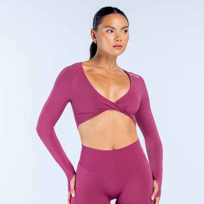 Twist-front long sleeve athletic top in deep plum with wide V-neck across the bust