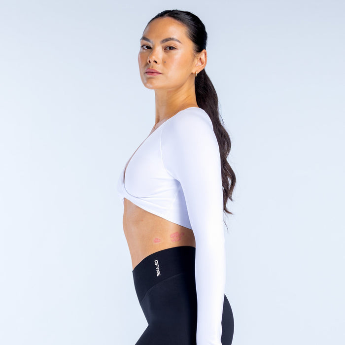 White long-sleeve twist-front V-neck sports top in side profile with cropped length