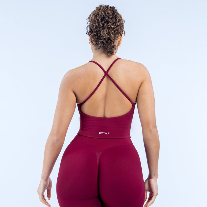 Burgundy strappy sports top with crisscross back straps and fitted scoop neckline