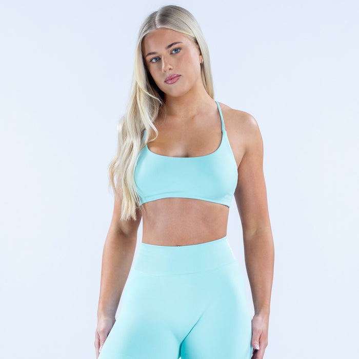 Women's light blue sports bra with racerback and twist at the back straps