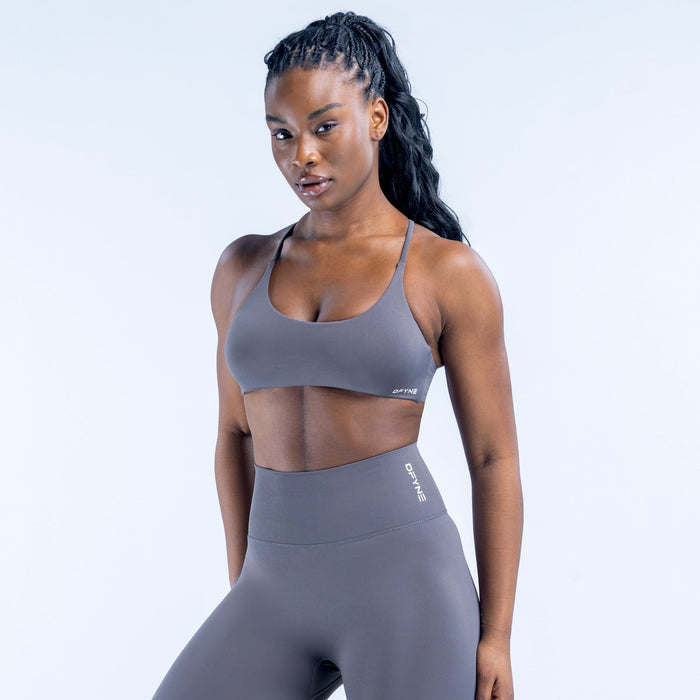 Dark gray sports bra with thin straps and small logo at center front