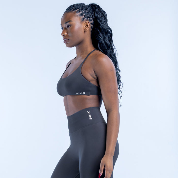 Dark sports bra with twisted open-back straps, side profile