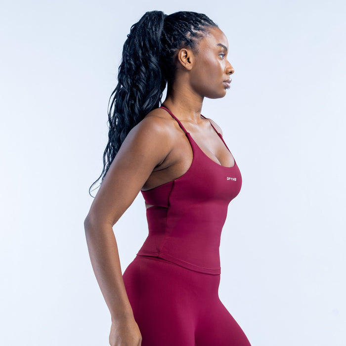 Burgundy twist-back sports top with crisscross straps, side view