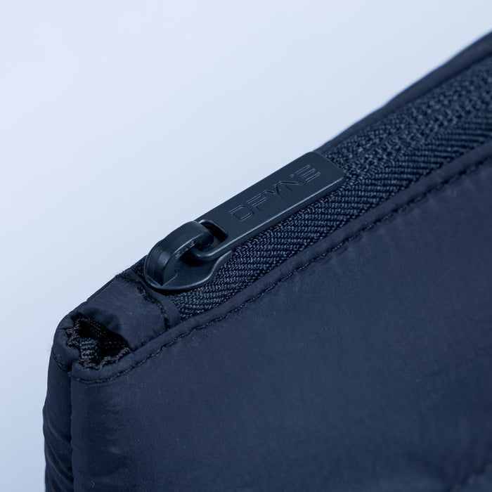 Dark navy pouch detail: black zipper pull with DEFY embossed webbing tab