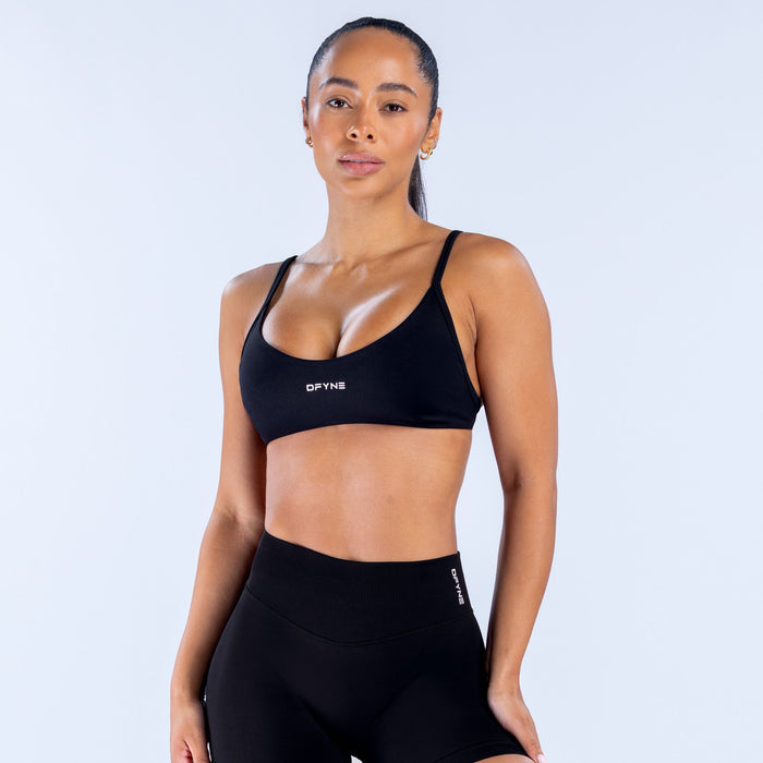 Black scoop-neck sports bra with racerback straps and DPYNE logo at center