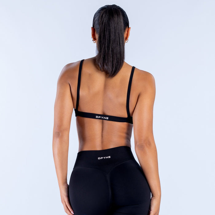 Black sports bra with racerback straps and DPYNE logo on back band