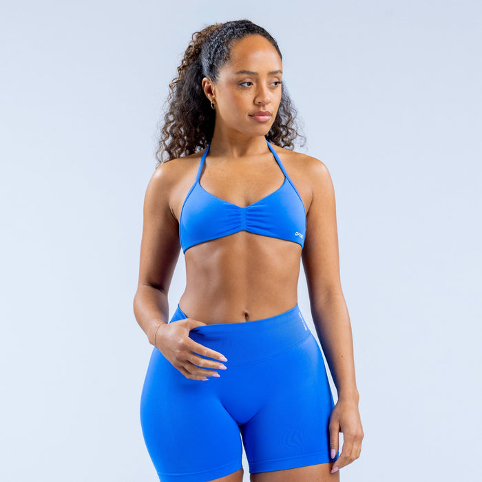 Blue strappy sports bra with thin adjustable straps and ruched center bust