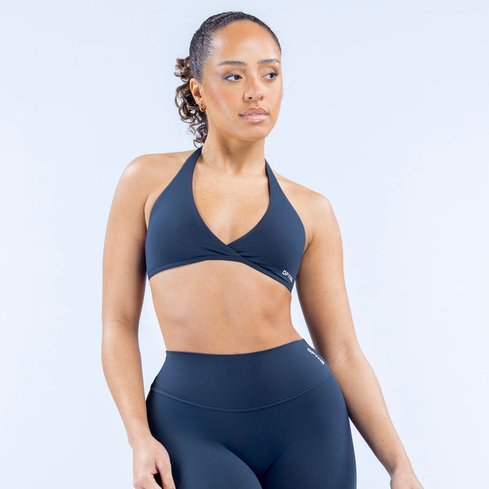Dark blue halter sports bra with V front and subtle logo on hem