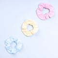 3-pack scrunchies in light pink, cream, and light blue with gathered elastic