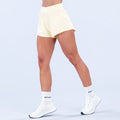 Light yellow training shorts with elastic waistband, above-knee length