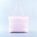 Light pink puffer tote bag with quilted panels and two top handles