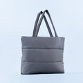 Gray puffer tote bag with two top handles and quilted horizontal baffles