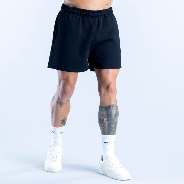 Dark athletic shorts with elastic waistband and straight hem, side profile view.