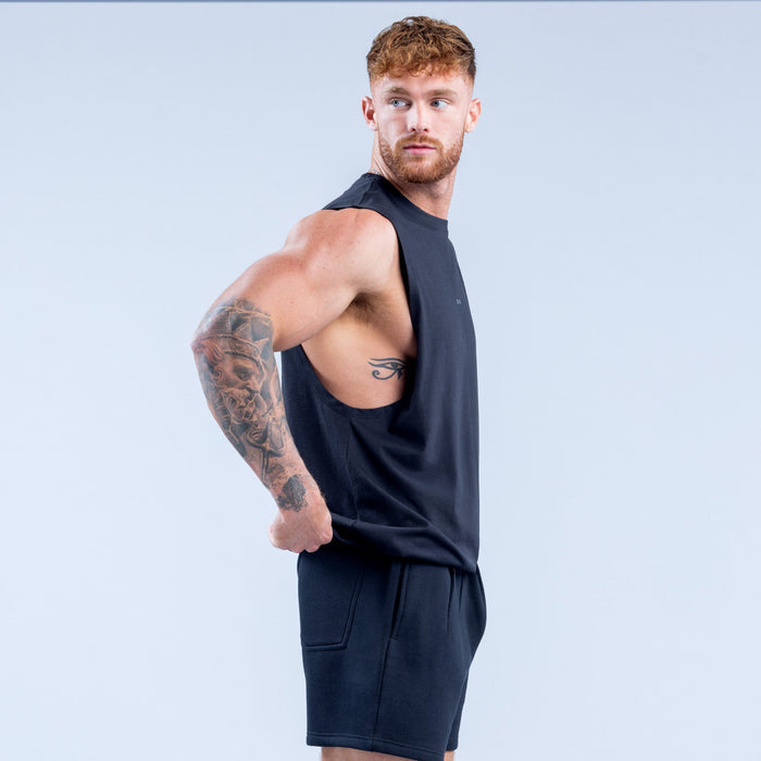 Men's dark sleeveless tank top with crew neck and small chest logo, close side view