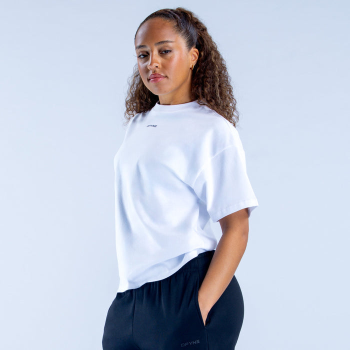 White boxy crew-neck T-shirt with short sleeves and small chest logo, side view
