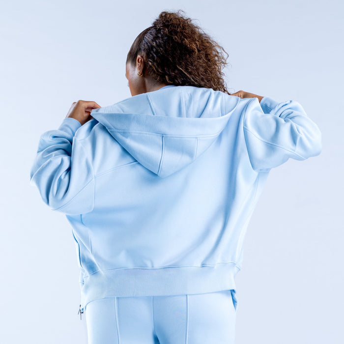 Light blue zip hoodie shown from back, with hood and relaxed hem