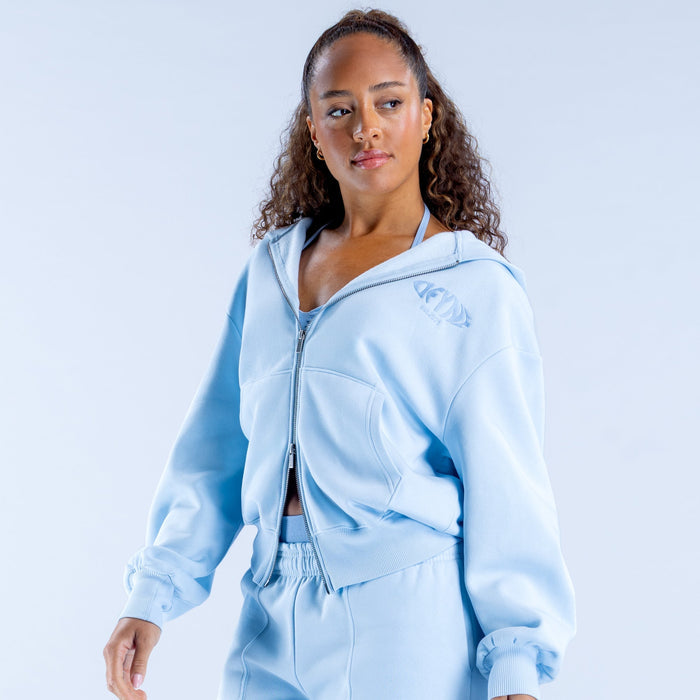 Light blue zip-up graphic hoodie with small chest logo near the zipper