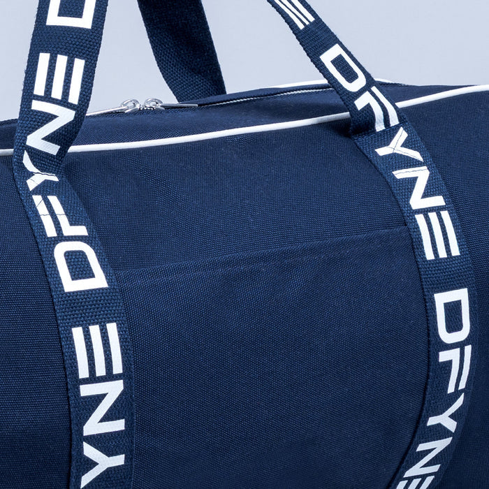 Navy duffle bag close-up with white logo strap and zipper pocket front