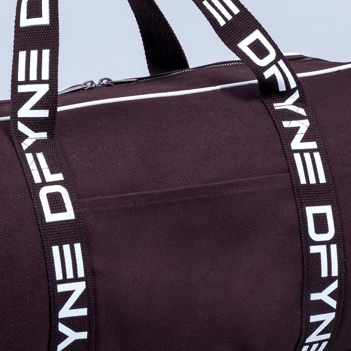 Burgundy duffle bag with white logo webbing shoulder strap and metal zipper