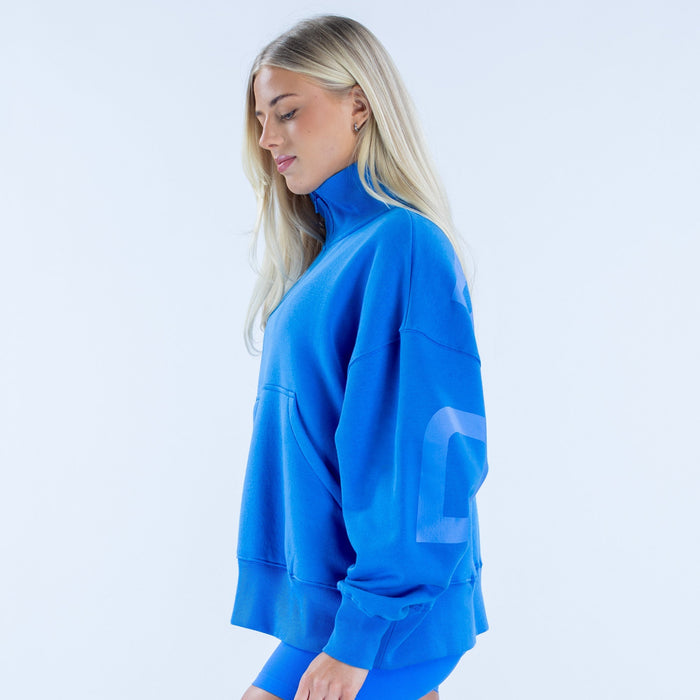 Blue quarter-zip sweatshirt with kangaroo pocket and ribbed cuffs, side profile