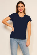 Woman wearing a black t-shirt and blue jeans against a plain background