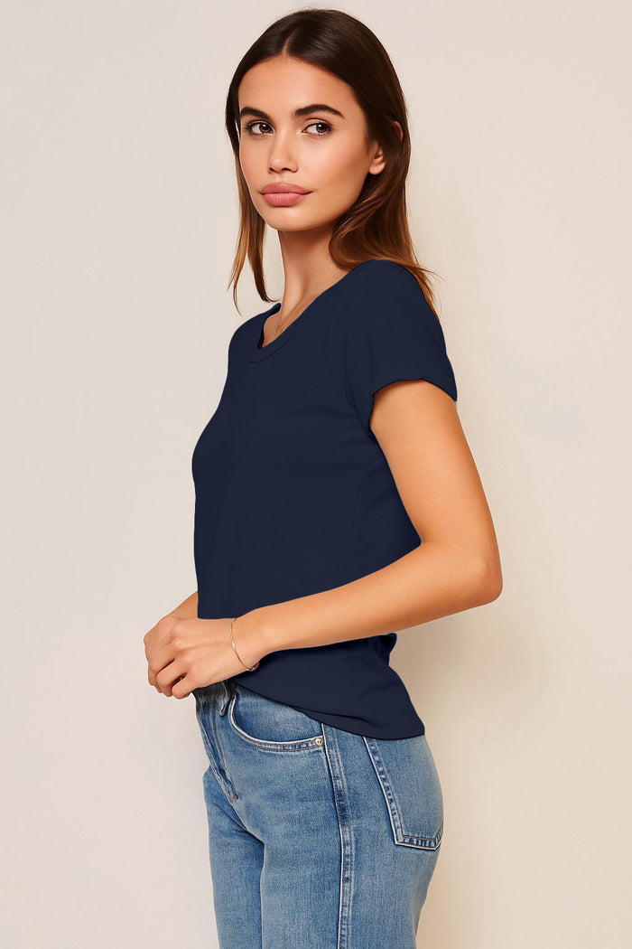 Woman wearing a navy blue t-shirt and jeans against a beige background
