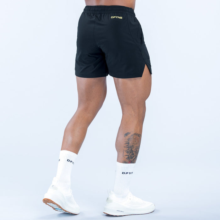 Men's black training shorts, back view with elastic waistband and logo trim
