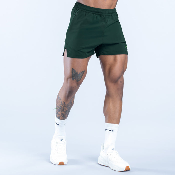 Green training shorts with adjustable drawstring waistband and logo on leg
