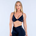 Twist-front sports bra in dark navy with DYPYN logo on left bust
