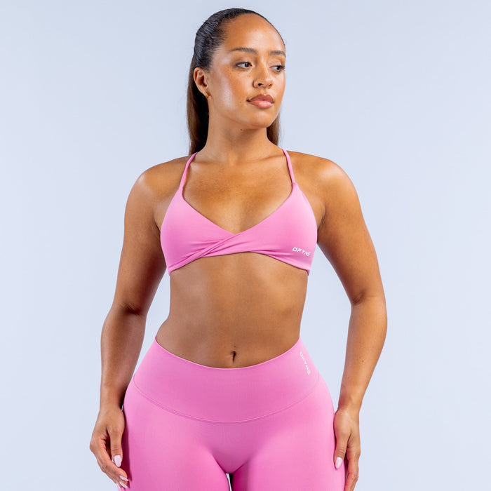 Pink twist-front sports bra with V-neck and crossover seam