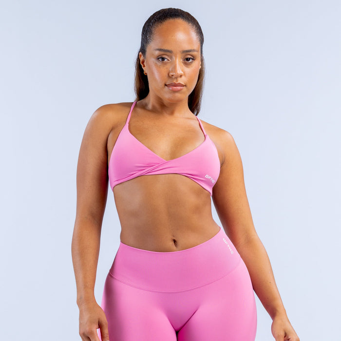 Pink twist-front sports bra with thin straps and supportive fit
